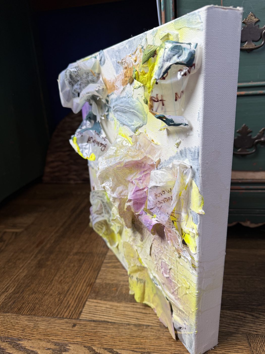 Side view of a canvas with sculpted resin paper lifting off the surface