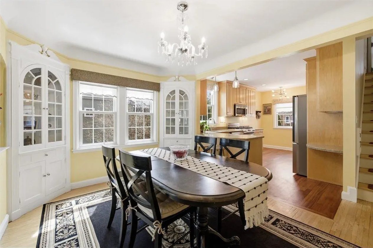 The same dining room before, pale yellow walls and white cabinetry